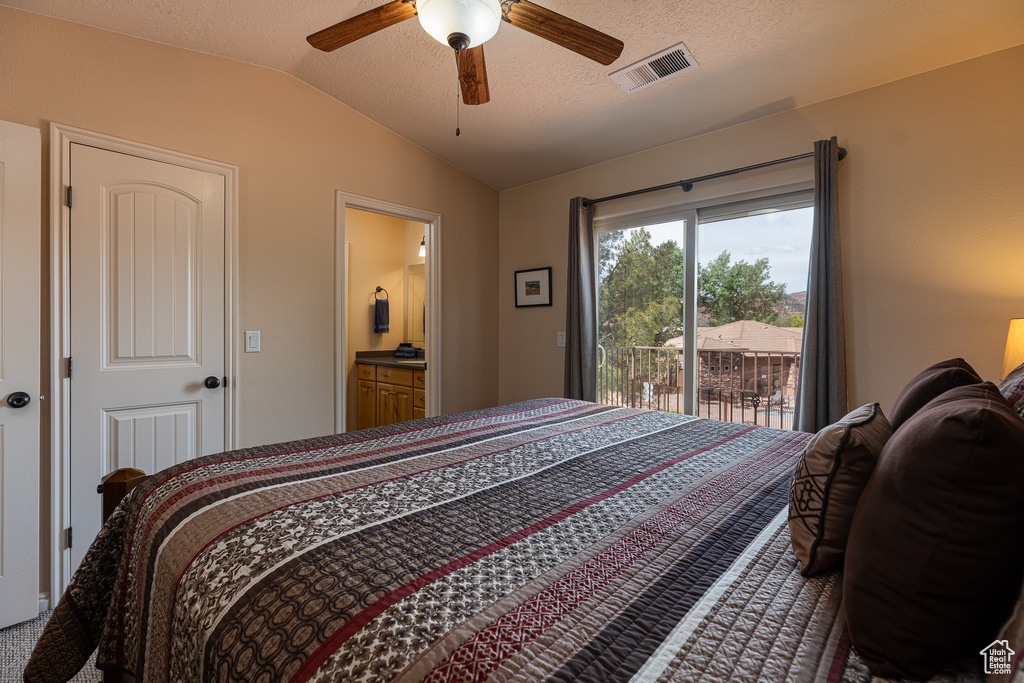Bedroom with vaulted ceiling, access to outside, a ceiling fan, and ensuite bath