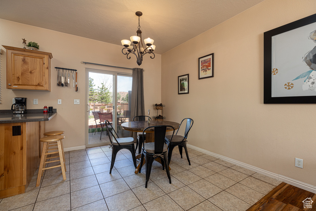 Dining area featuring a chandelier, baseboards, and light tile patterned floors
