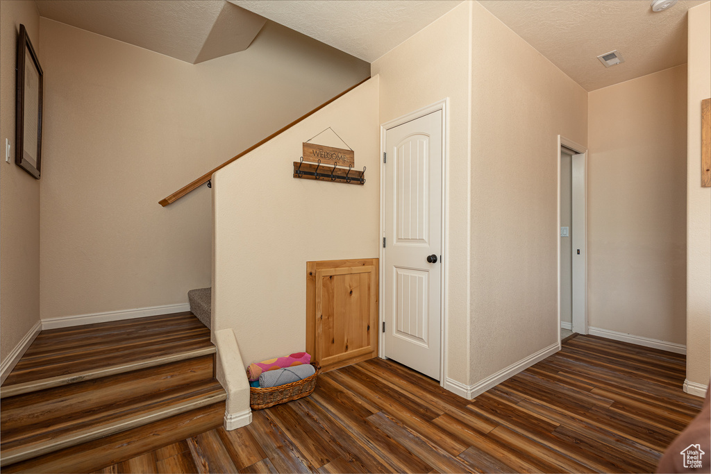 Stairs with wood finished floors and baseboards