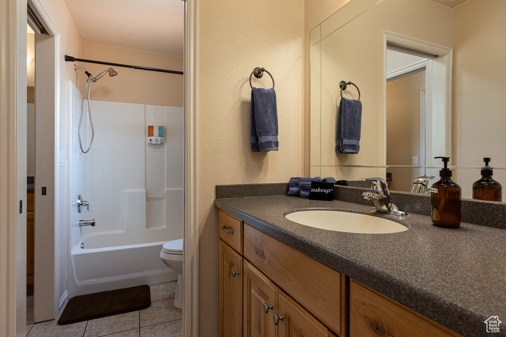 Bathroom with toilet, tile patterned floors, vanity, and tub / shower combination