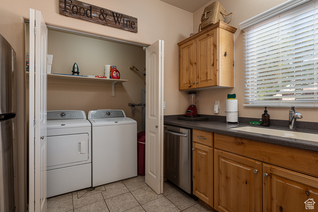 Laundry area featuring washing machine and dryer and light tile patterned floors