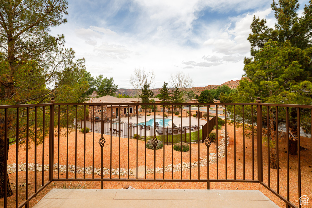 Balcony featuring view of pool and a patio