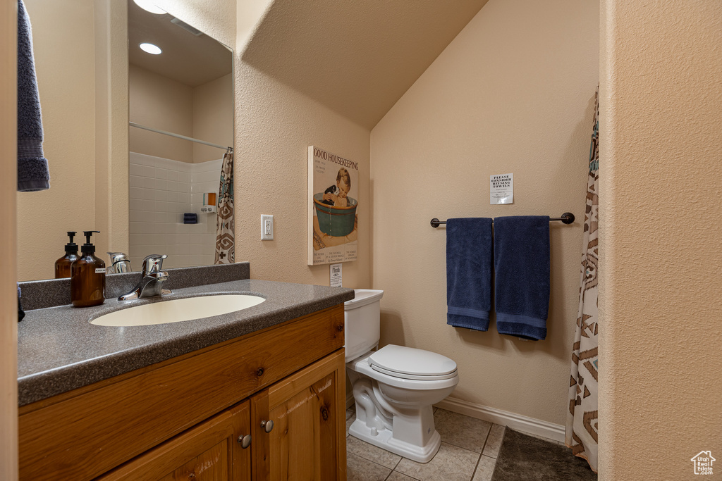 Bathroom featuring toilet, tile patterned floors, vanity, a shower with curtain, and baseboards