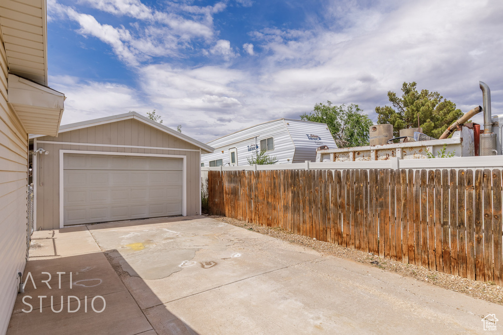 Garage featuring fence and driveway
