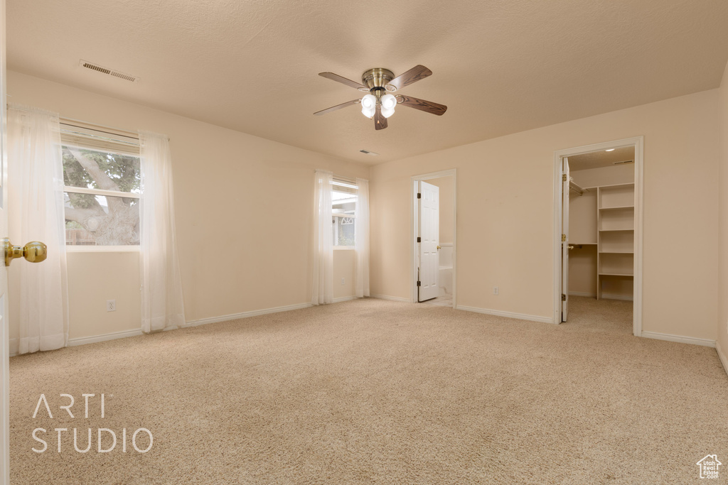 Unfurnished bedroom with visible vents, carpet, a walk in closet, and baseboards