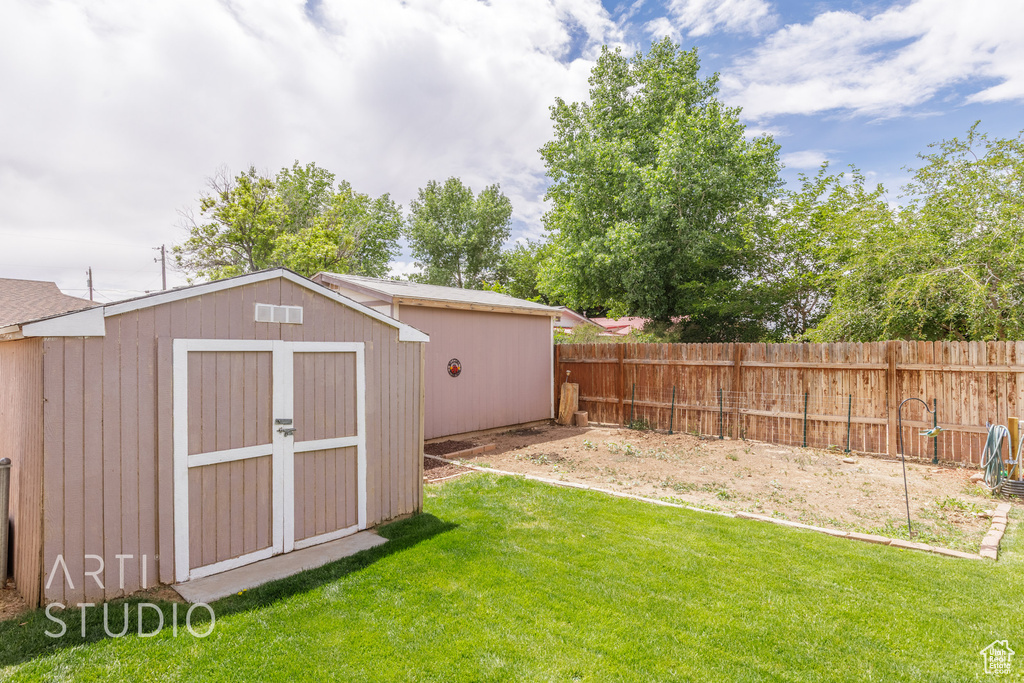 View of yard with an outbuilding, a fenced backyard, and a storage unit