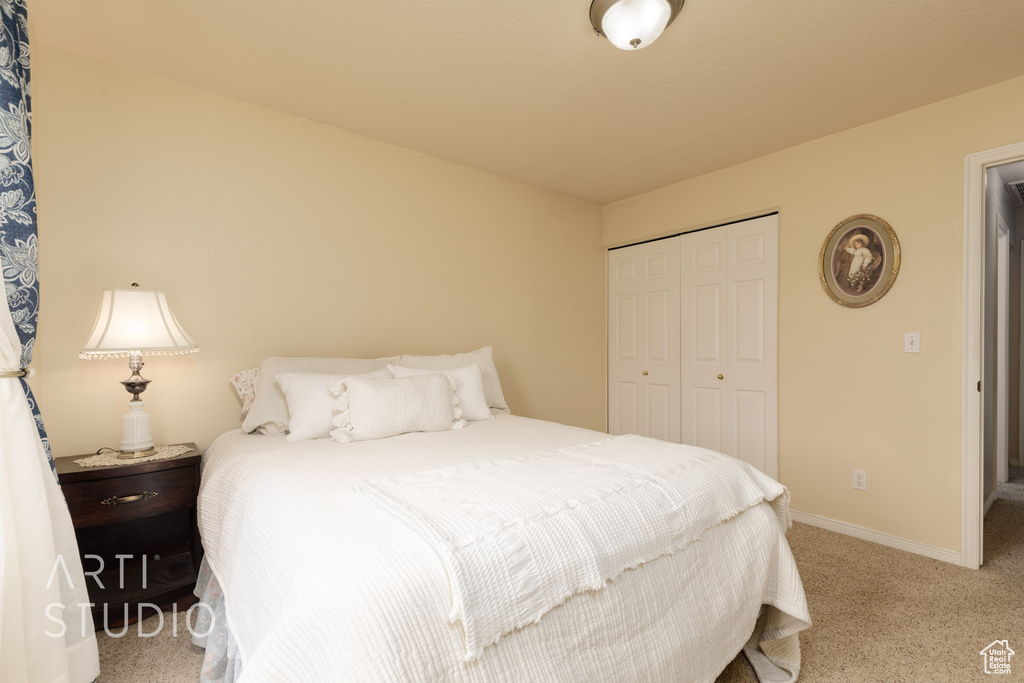 Bedroom with carpet floors, baseboards, and a closet