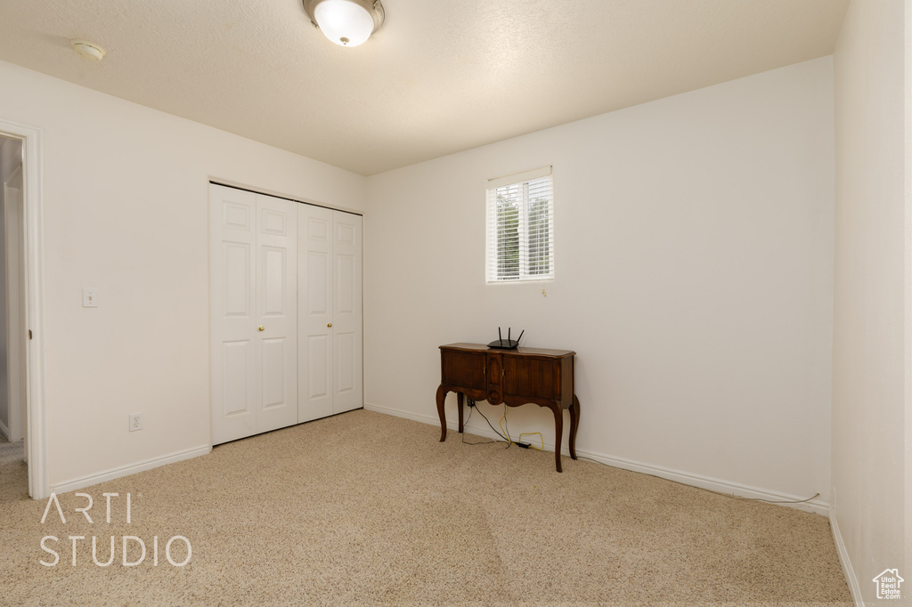 Bedroom featuring carpet flooring, baseboards, and a closet
