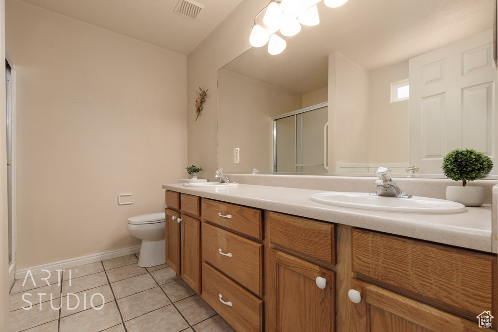 Bathroom featuring visible vents, tile patterned flooring, a shower stall, a sink, and toilet