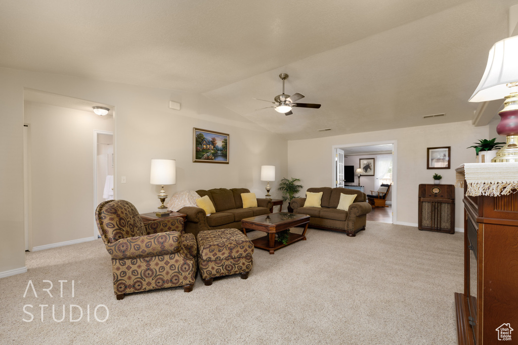 Living room featuring carpet flooring, ceiling fan, baseboards, and lofted ceiling