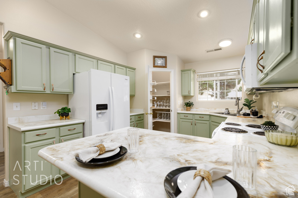 Kitchen with visible vents, white appliances, recessed lighting, a sink, and green cabinets