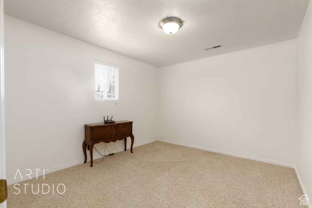 Carpeted empty room featuring baseboards and visible vents