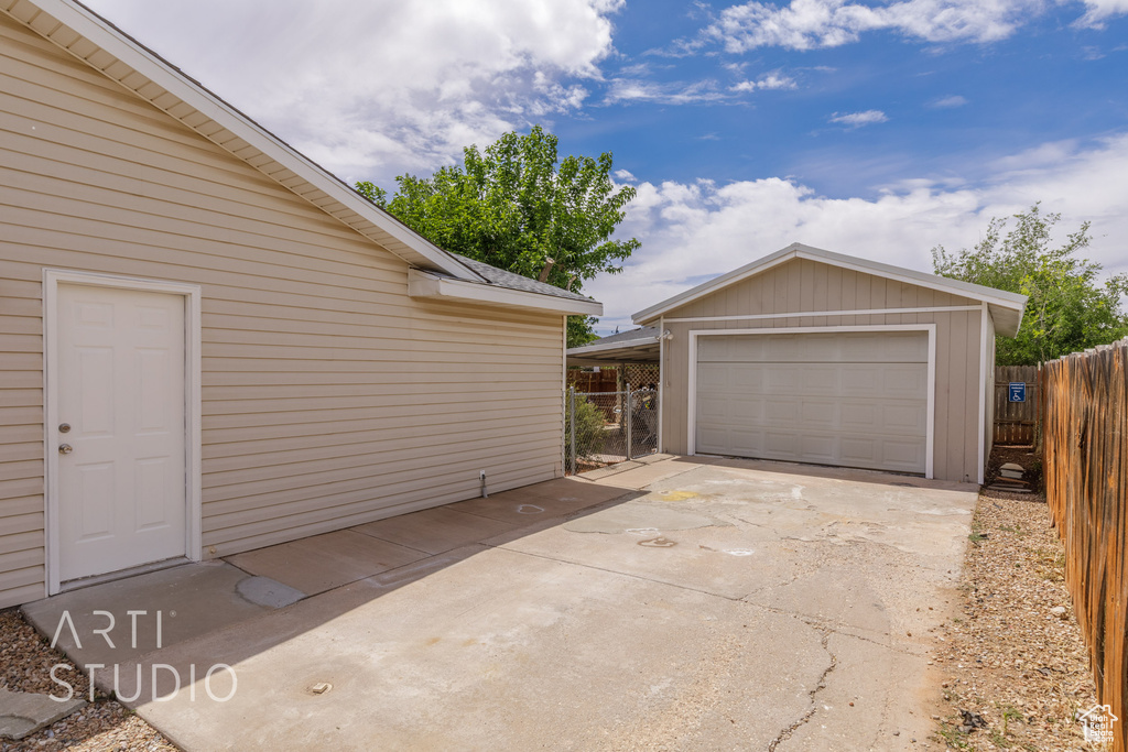Detached garage featuring fence and driveway