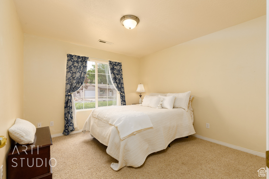 Carpeted bedroom with baseboards and visible vents
