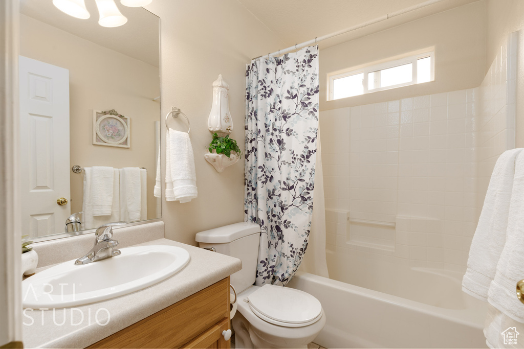 Full bath with vanity, shower / bath combo, and toilet