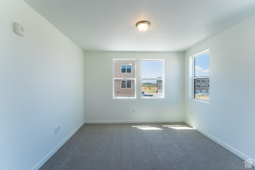 Carpeted empty room with baseboards