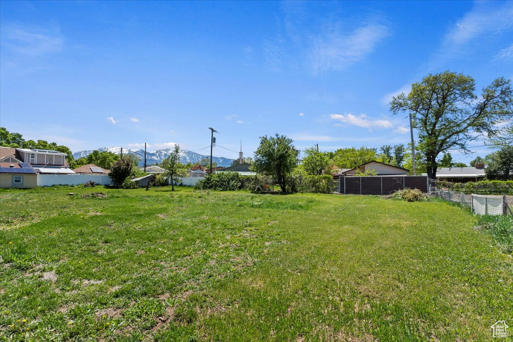 View of yard featuring fence and a mountain view