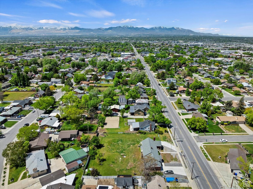 Aerial view of property and surrounding area with a mountainous background and nearby suburban area