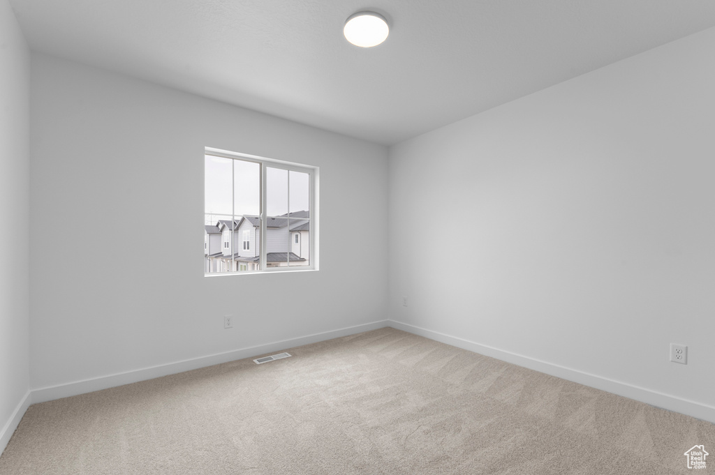 Unfurnished room with baseboards, carpet, and visible vents