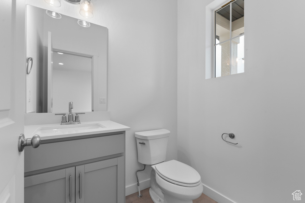 Bathroom featuring toilet, baseboards, and vanity