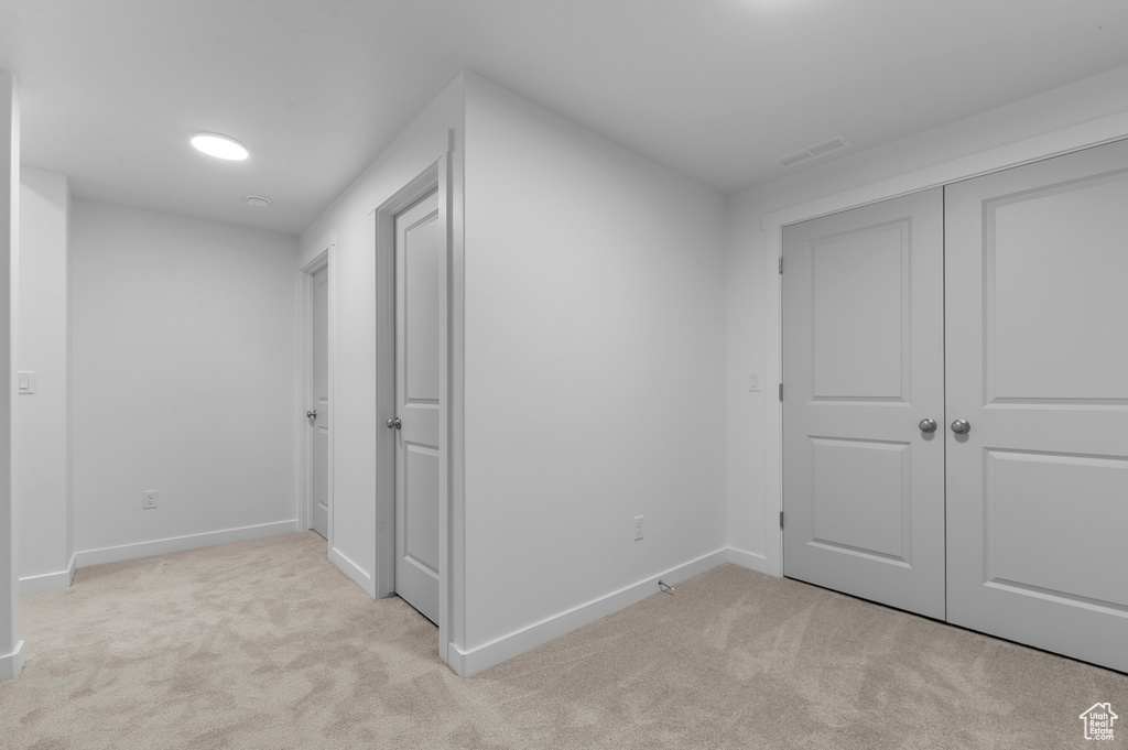 Unfurnished bedroom featuring carpet floors, baseboards, visible vents, and a closet