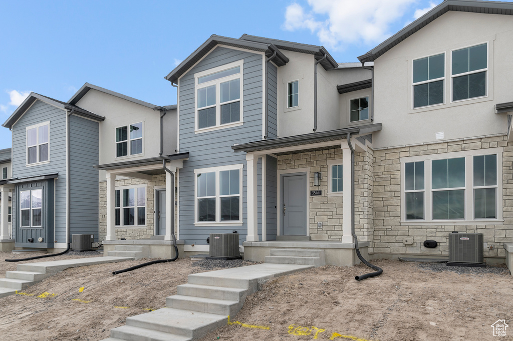 Townhome / multi-family property with central AC and stone siding