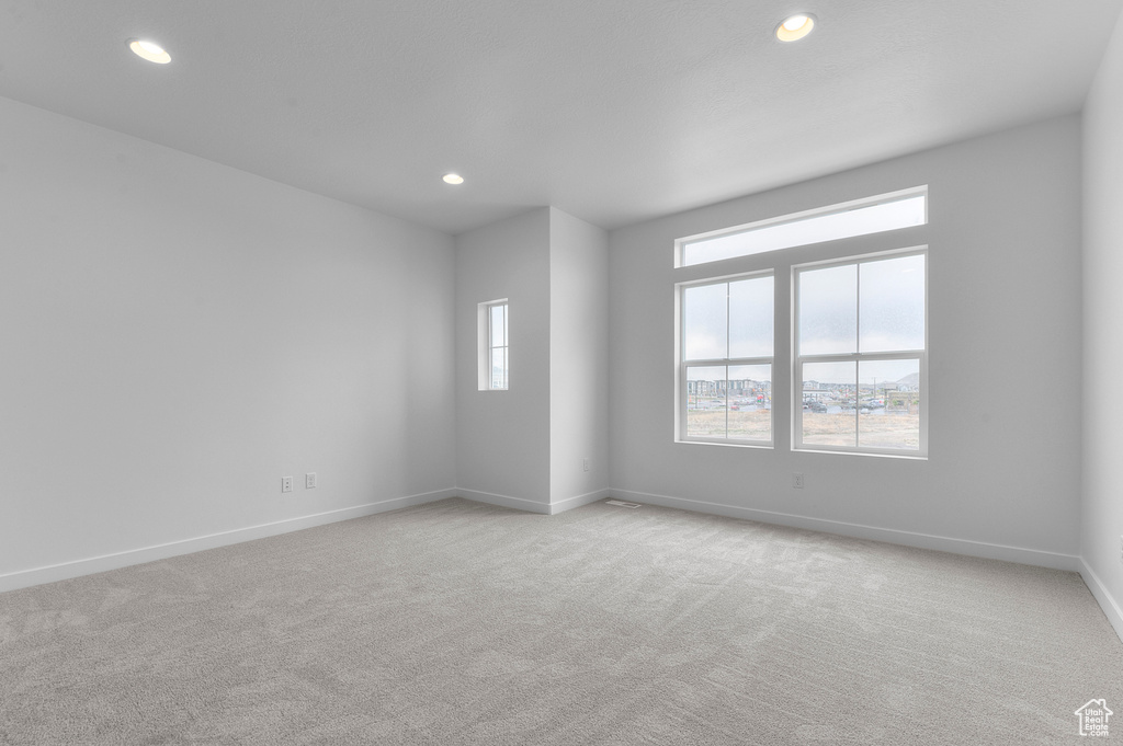 Spare room featuring recessed lighting, baseboards, and light colored carpet