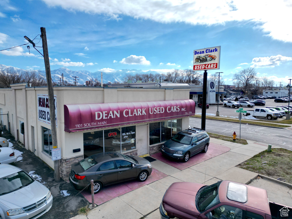 View of property with uncovered parking and a mountain view
