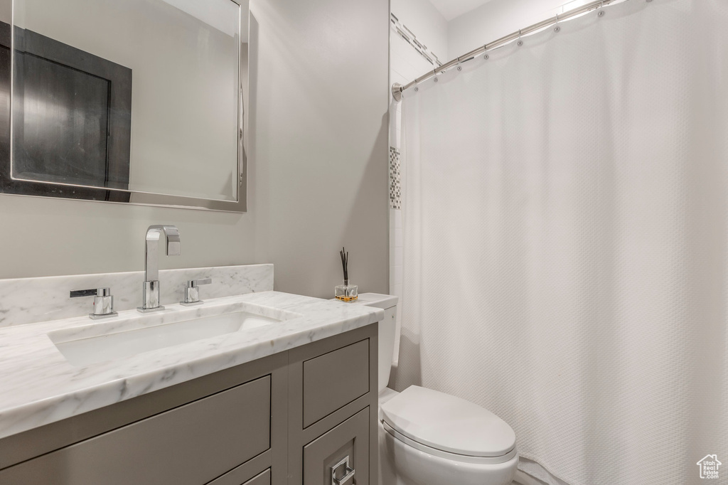 Bathroom with vanity, toilet, and shower / bath combination with curtain