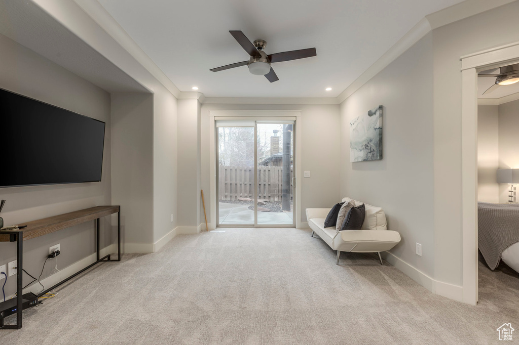 Sitting room featuring crown molding, a ceiling fan, and carpet