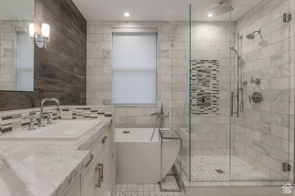 Full bathroom with a freestanding tub, tile walls, a shower stall, and vanity