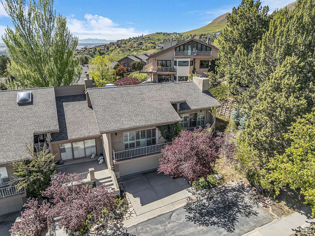 View of front of house featuring roof with shingles, a mountain view, and a balcony