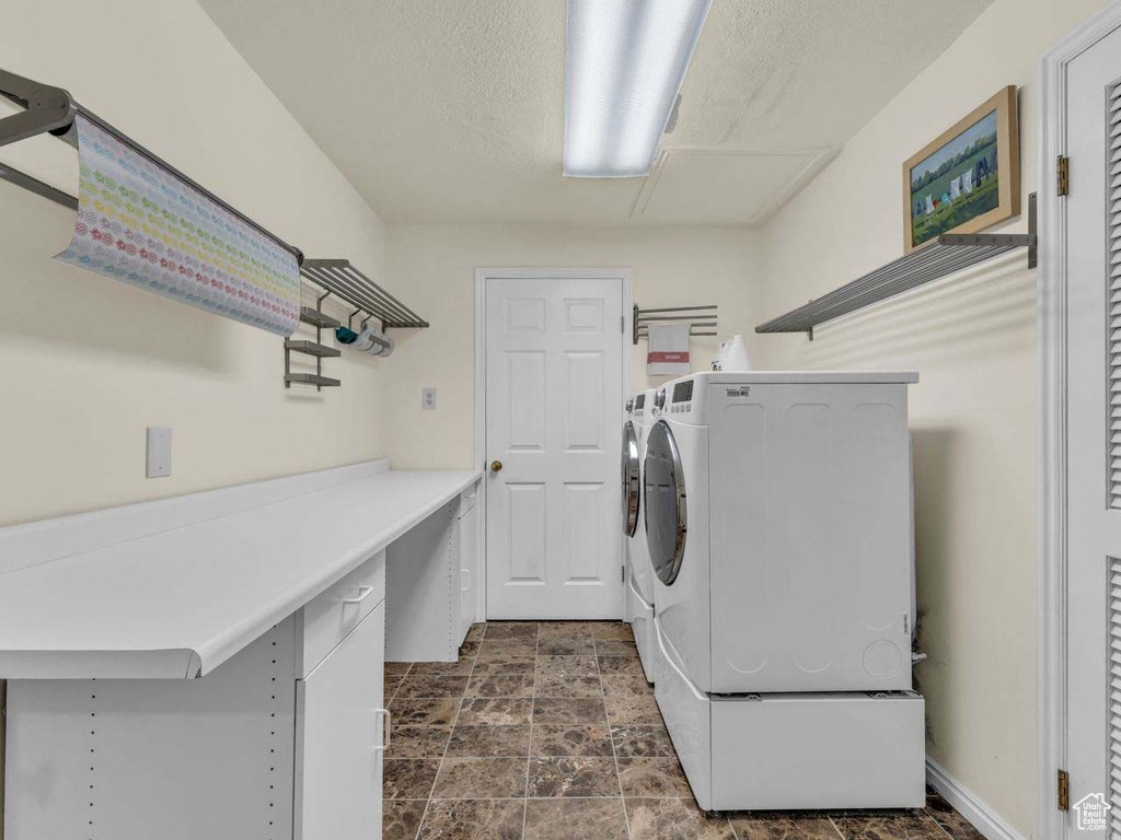 Washroom with laundry area, stone finish flooring, and washer and dryer
