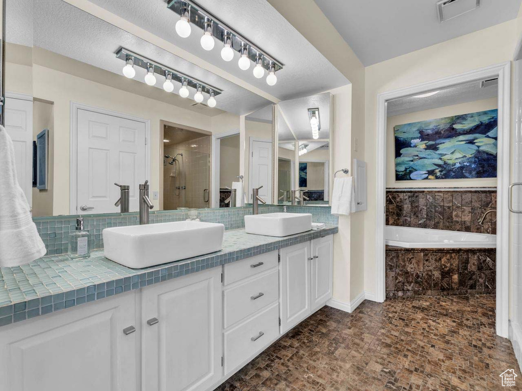 Full bath featuring a sink, a stall shower, double vanity, and visible vents