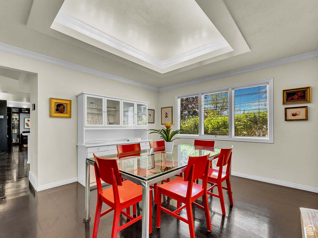 Dining area featuring baseboards, ornamental molding, and a tray ceiling