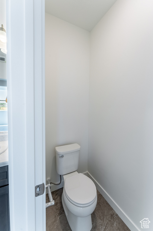 Bathroom featuring toilet, baseboards, and visible vents