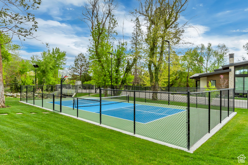 View of sport court featuring a lawn and fence