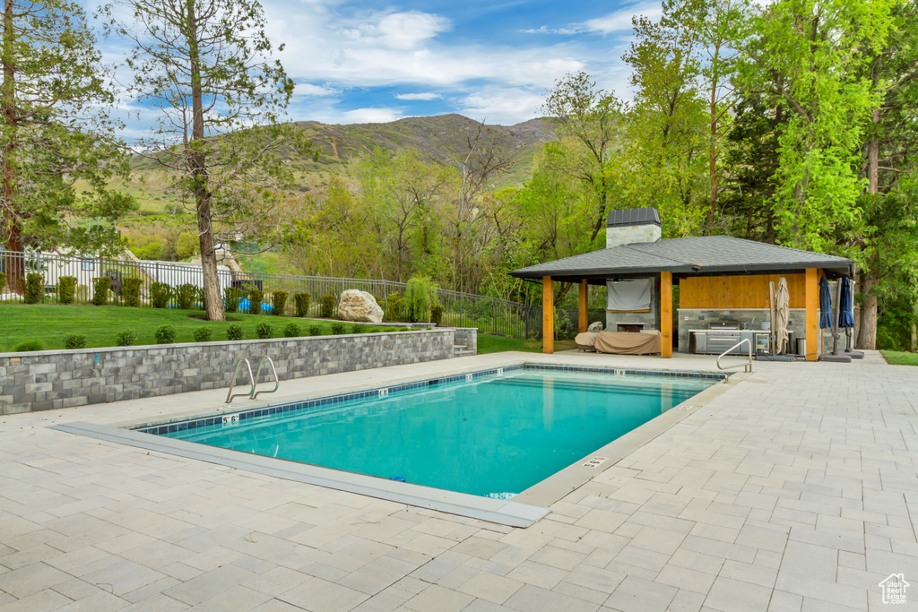 Community pool featuring a gazebo, a fenced backyard, a mountain view, a patio area, and a yard