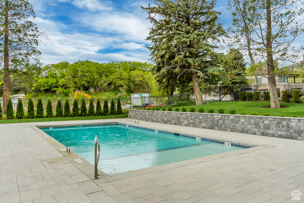 Pool with a yard, a patio, and fence
