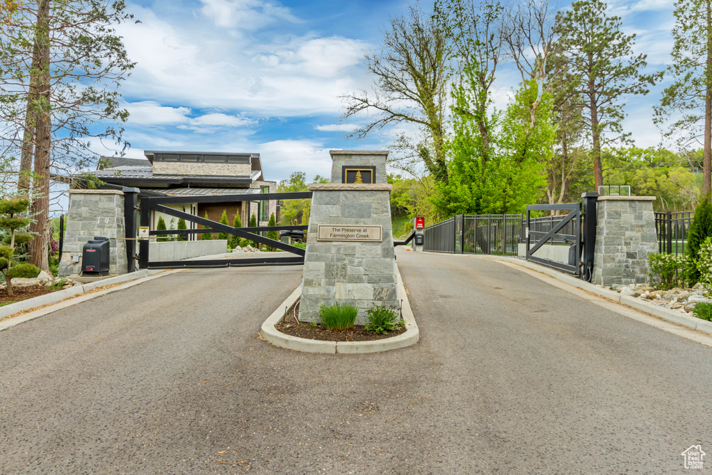 View of street featuring a gated entry, a gate, and curbs