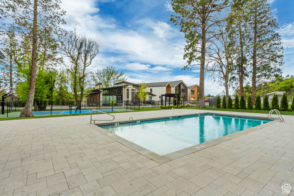 Pool featuring a tennis court and fence