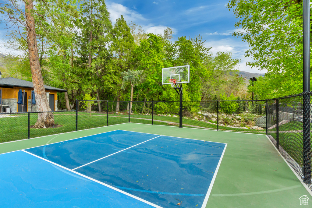 View of sport court featuring fence, community basketball court, and a lawn