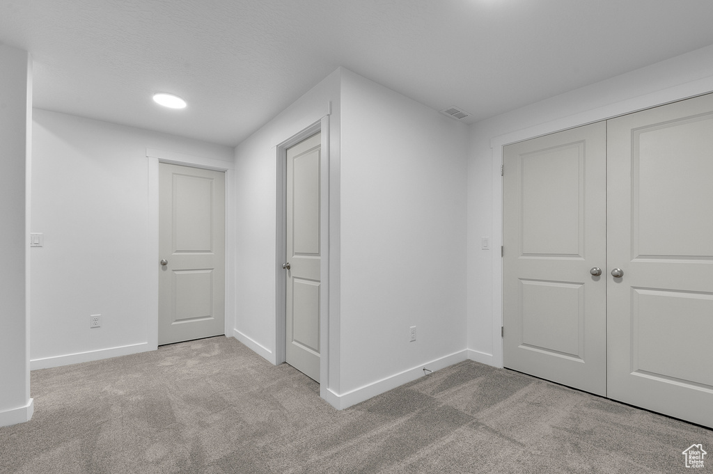 Unfurnished bedroom with baseboards, carpet, and a closet
