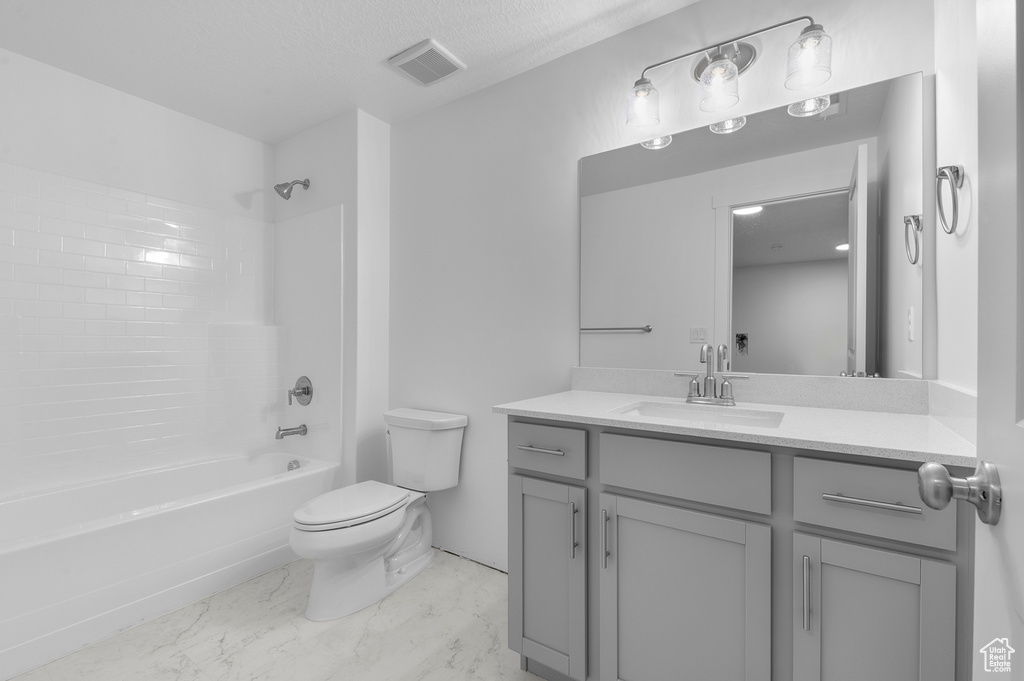 Bathroom with visible vents, vanity, marble finish floor, toilet, and  shower combination