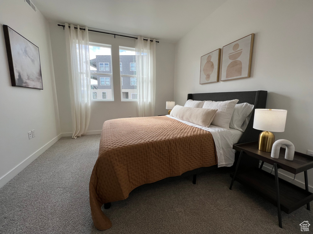 Carpeted bedroom featuring visible vents and baseboards