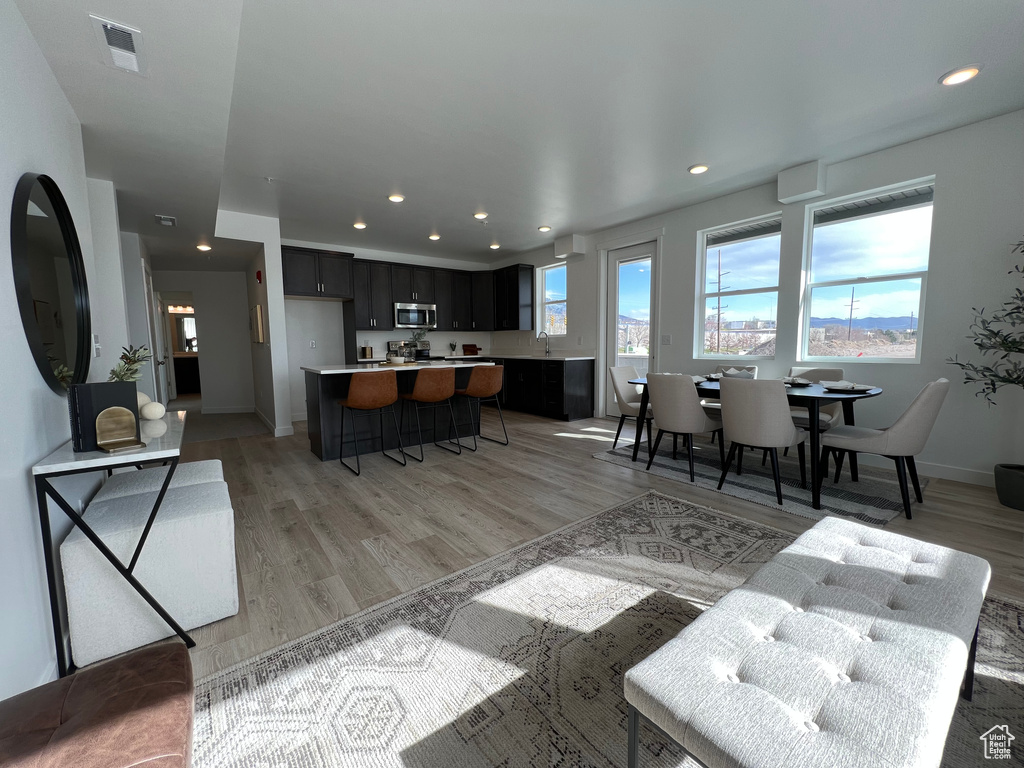 Living area with recessed lighting, baseboards, visible vents, and light wood-style flooring
