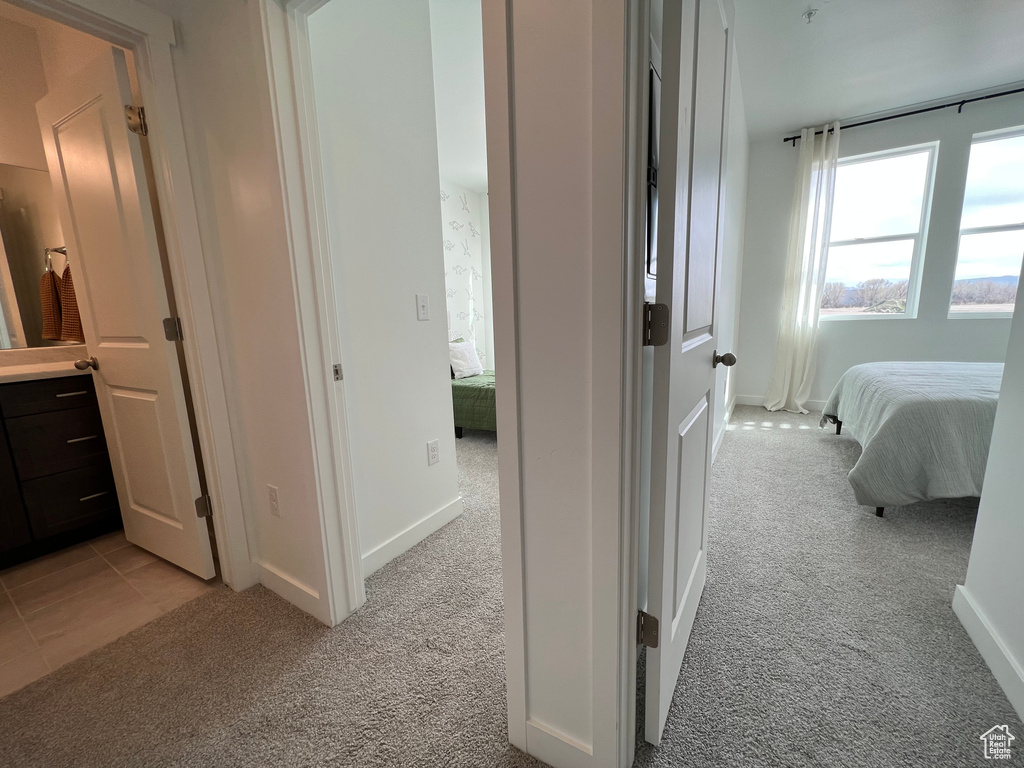 Hall featuring baseboards and light carpet
