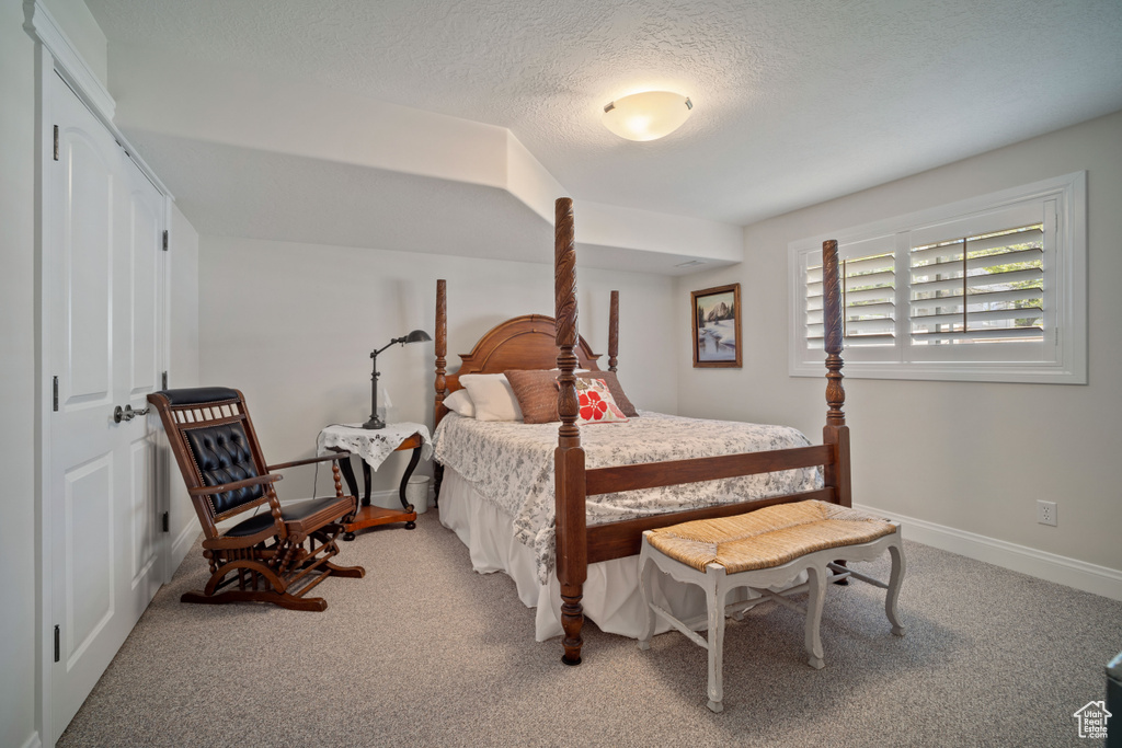 Bedroom with carpet floors, a textured ceiling, and baseboards