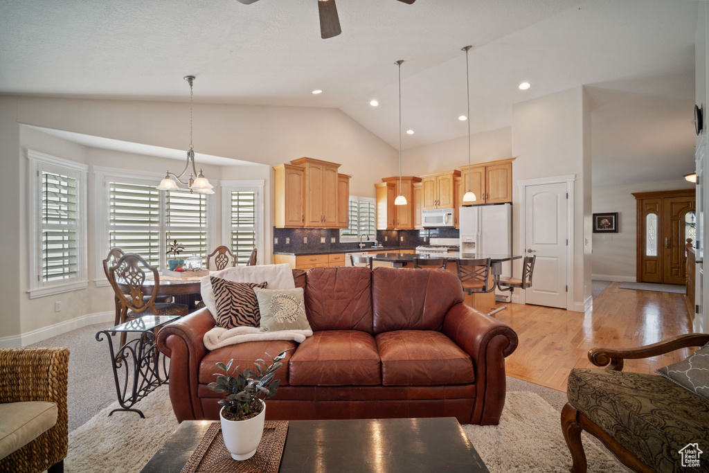 Living room with baseboards, a ceiling fan, and a healthy amount of sunlight