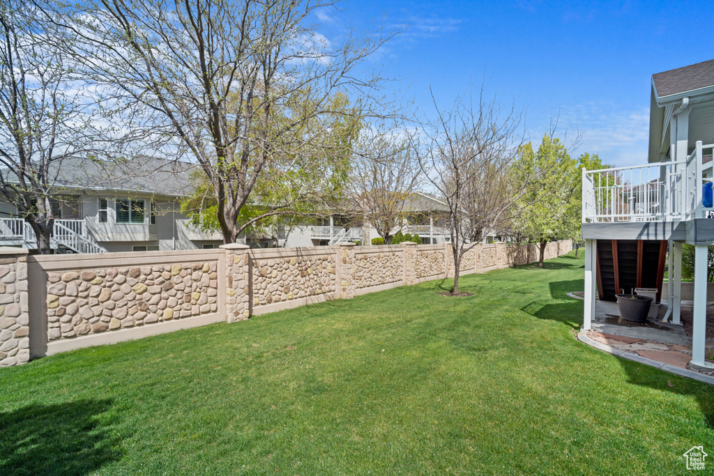 View of yard with fence and a deck